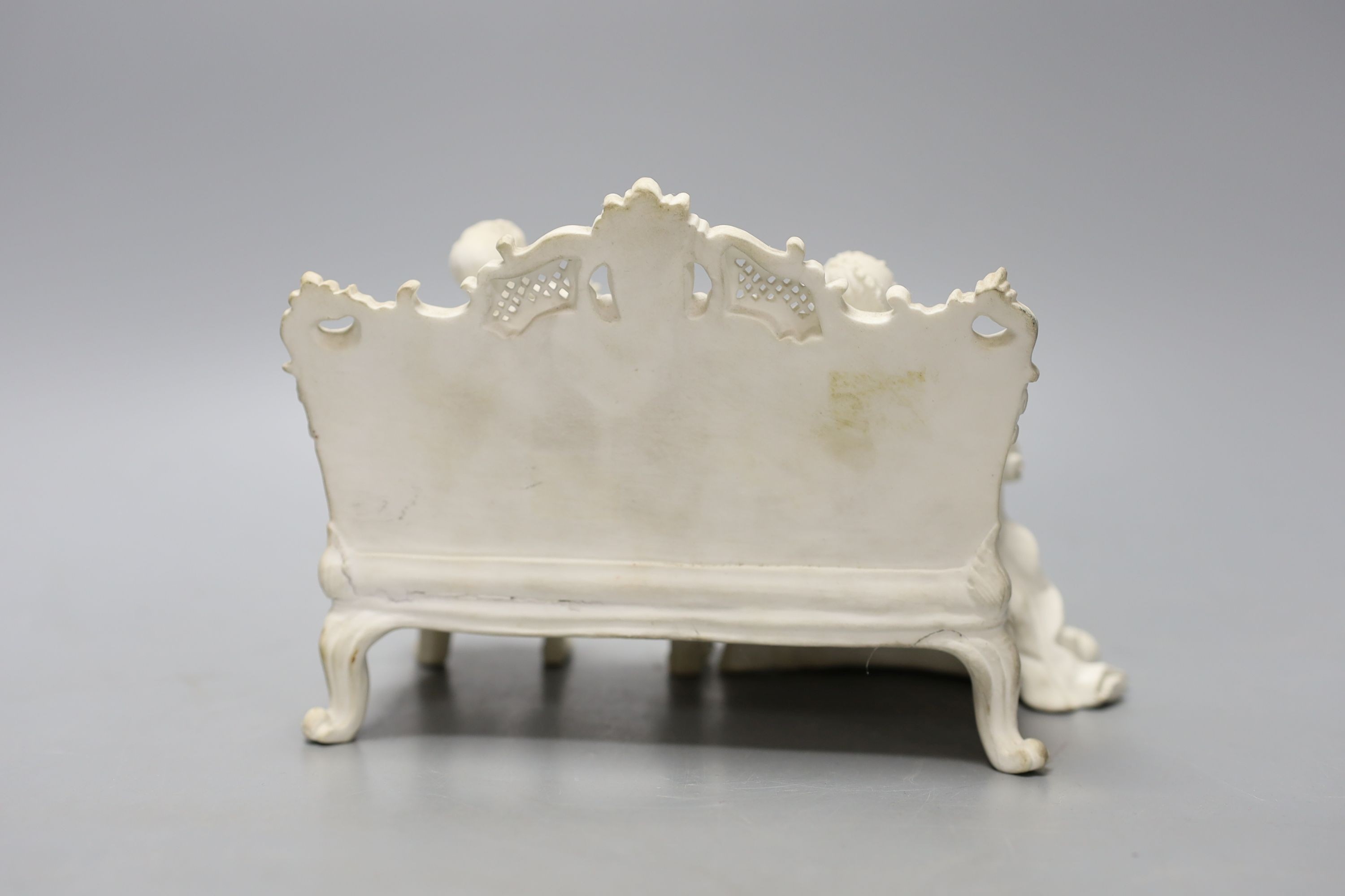 19th century English biscuit group of a woman with a mandolin and a man with a flute seated on an elaborate settee, 20 cm wide